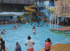 A swimming pool with multiple slides and a diving platform. - Suite Pakar Hotel (Berastagi)