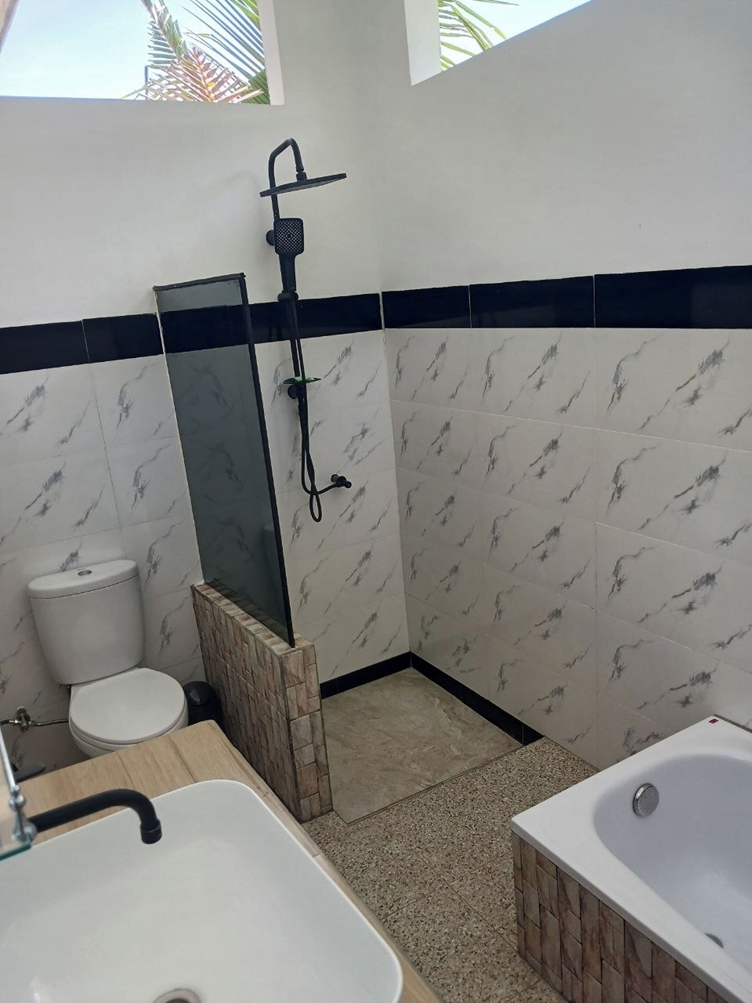 A bathroom with a shower, toilet, sink, and bathtub.