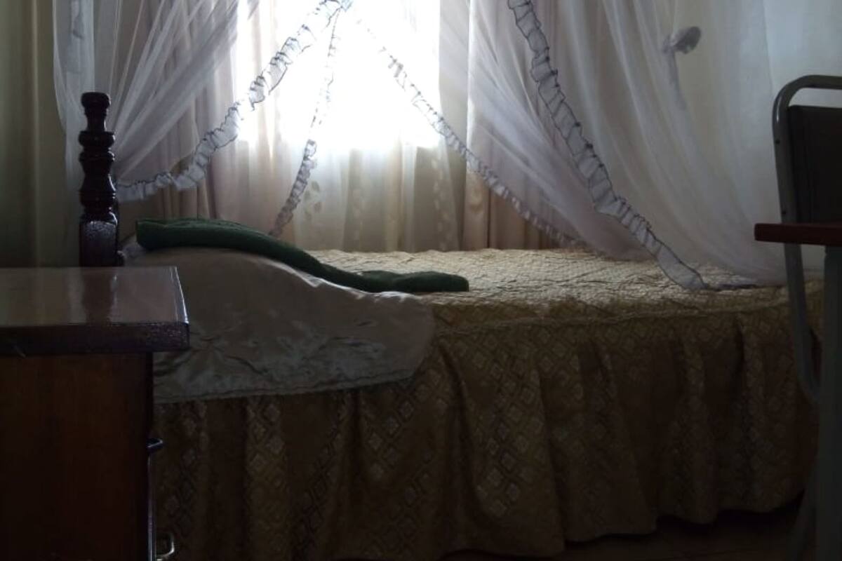 Un dormitorio con cama, escritorio y silla.