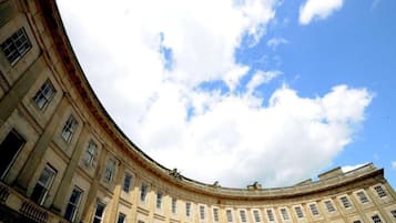 A large, curved building with multiple windows and a classical architectural style.