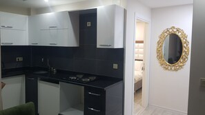 Suite Deluxe | Cocina básica privada | Frigorífico pequeño, placa de cocina y hervidor eléctrico