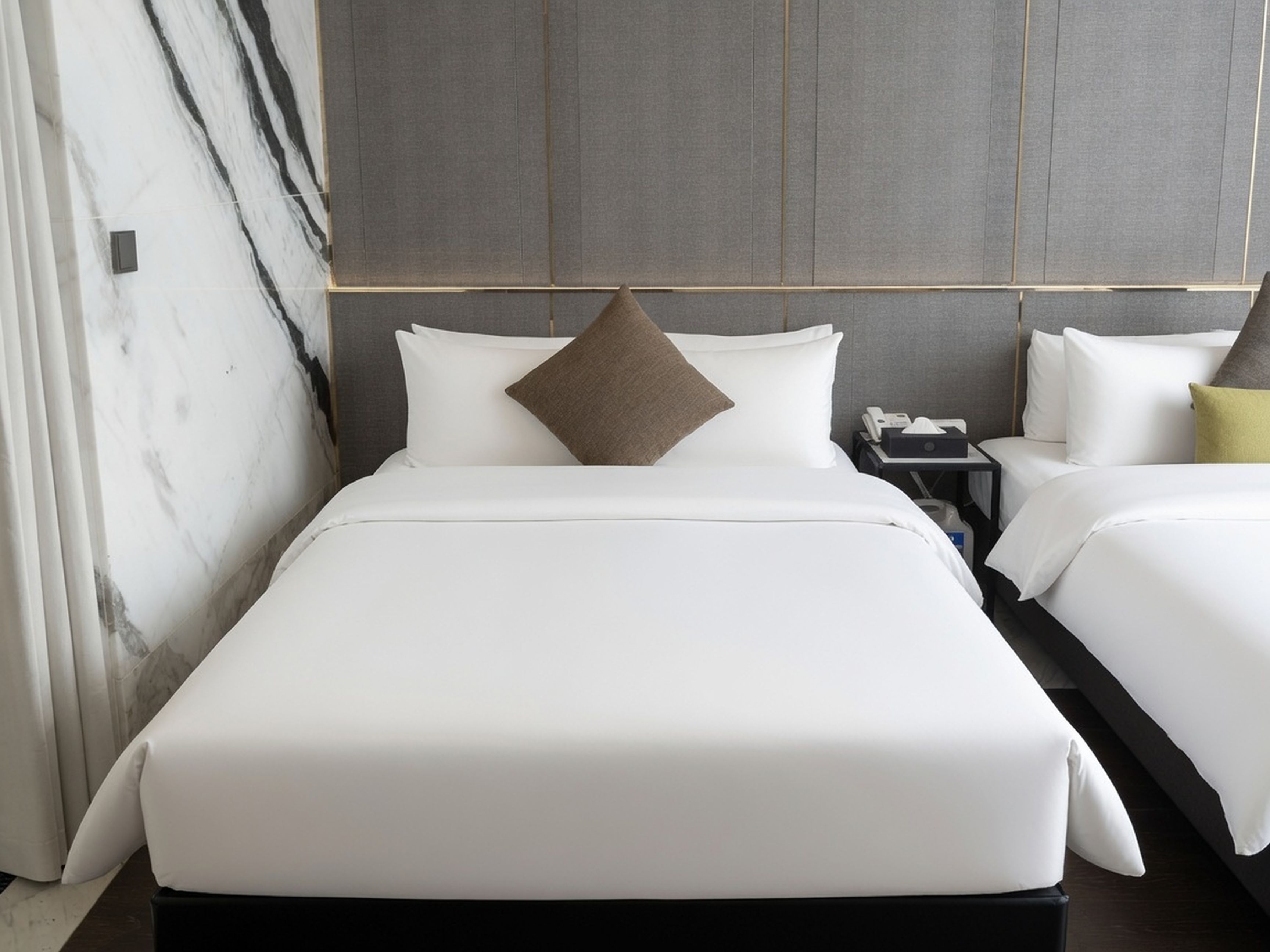 Una habitación de hotel con una cama grande, una mesita de noche y un velador.