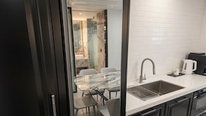 A modern kitchen with a marble countertop, a sink, and a coffee maker. - The May Hotel (Seoul)
