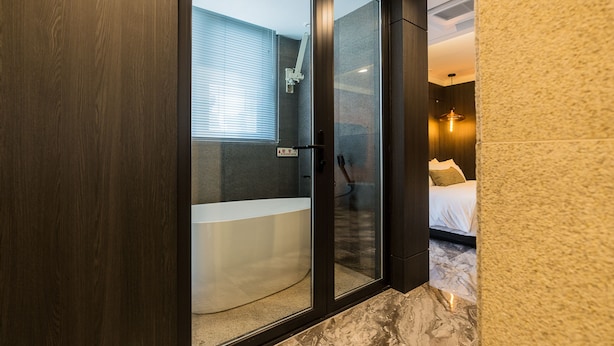A modern bathroom with a glass-enclosed shower, a bathtub, and a visible toilet. - The May Hotel (Seoul)
