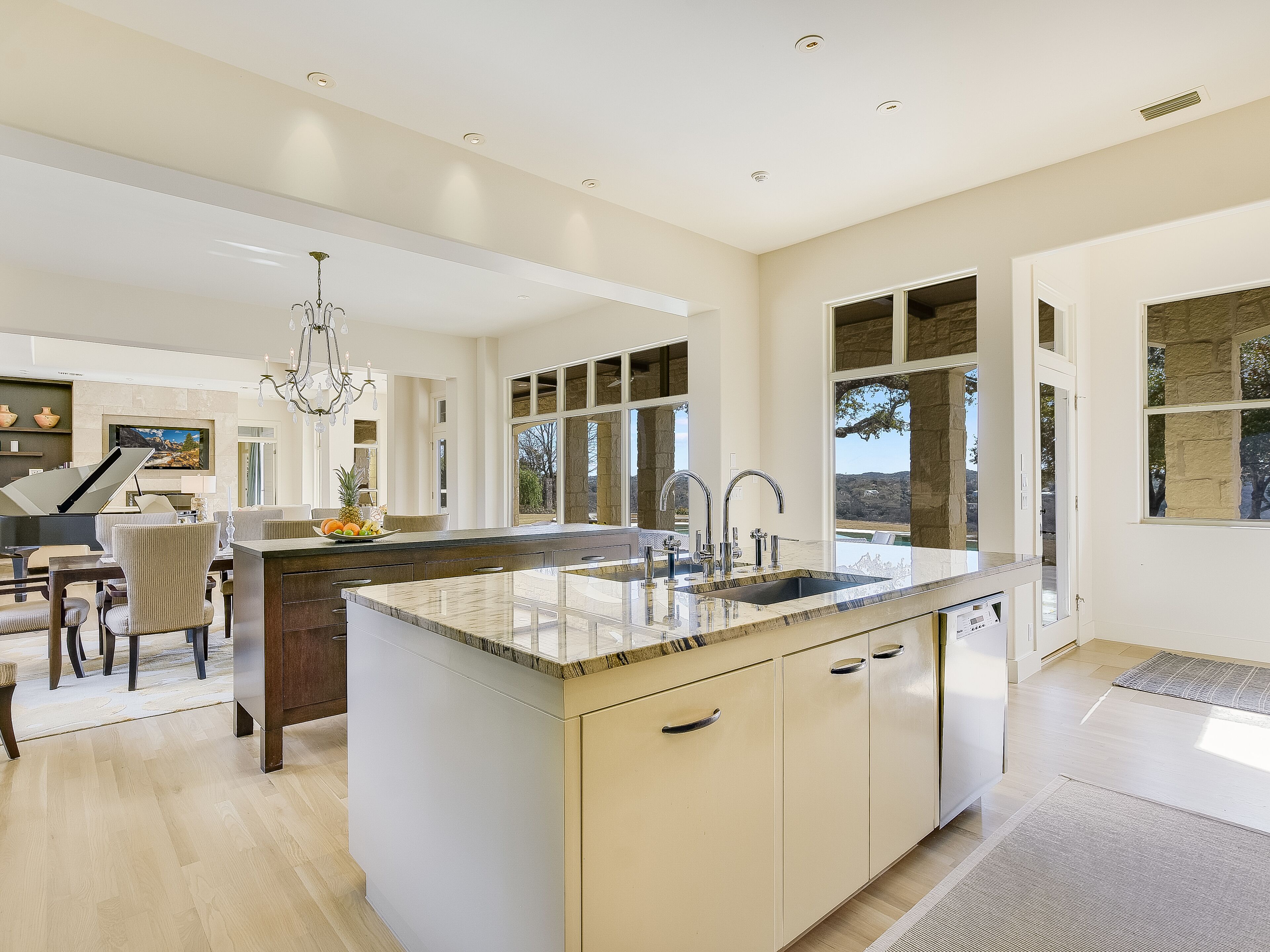 Een ruime keuken met een groot eiland, moderne apparaten en uitzicht op de omgeving.