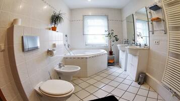 Bathtub, bathtub dengan aliran air, dan handuk