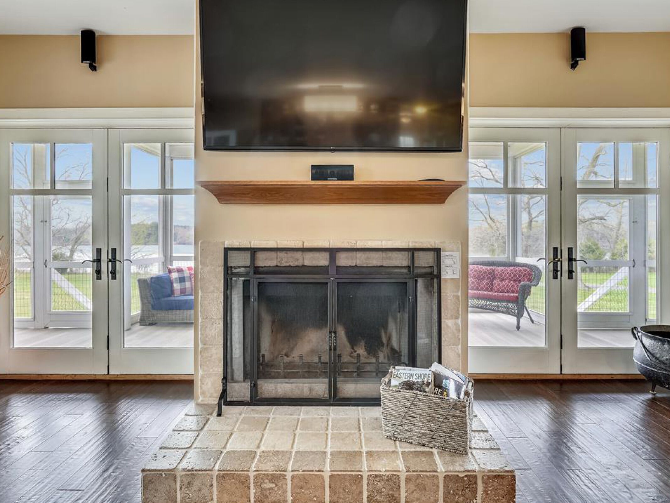 Un salón amplio con chimenea, ventanas grandes y un televisor de pantalla plana montado en la pared.