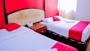 A hotel room with two beds, red and white bedding, a wooden headboard, and a bedside table with a telephone. - Oyo 424 Kk Inn Hotel (Ampang)