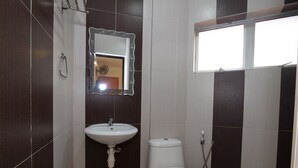 A small bathroom with a white sink, a toilet, and a mirror above the sink. - Oyo 424 Kk Inn Hotel (Ampang)