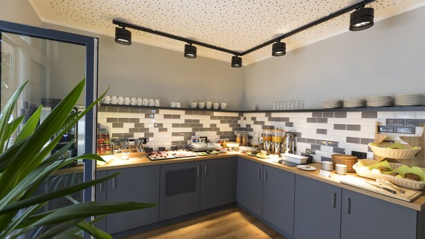 A modern kitchen with grey cabinets, a tiled backsplash, and various breakfast items on the counter. - mk | monteurzimmer eschborn (Eschborn)