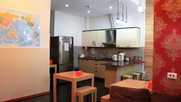 Nevera en la zona común, microondas, horno y placa de cocina