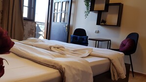 A hotel room with a bed, a chair, a small table, and a window with bars. - Envoy Hostel (Tbilisi)