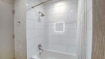 Un baño moderno con una bañera independiente, un cabezal de ducha y un perchero para toallas.