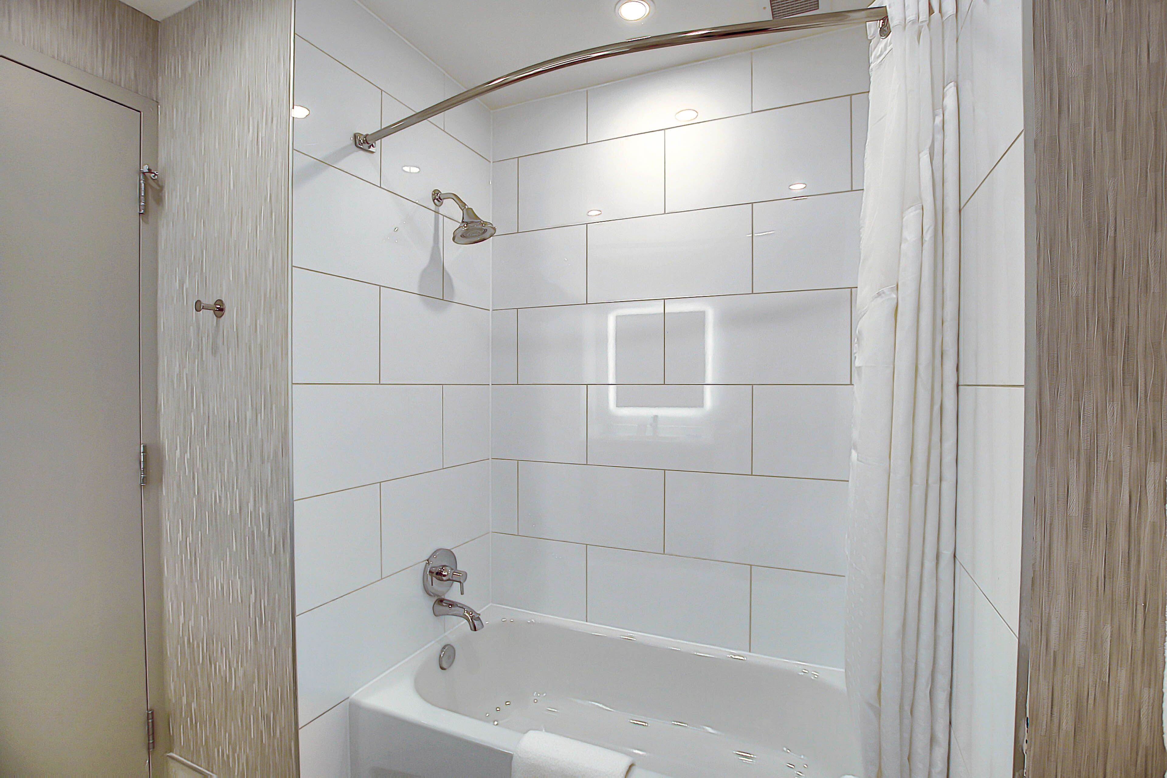 Une salle de bain moderne avec une baignoire sur pieds, une douche et un porte-serviettes.
