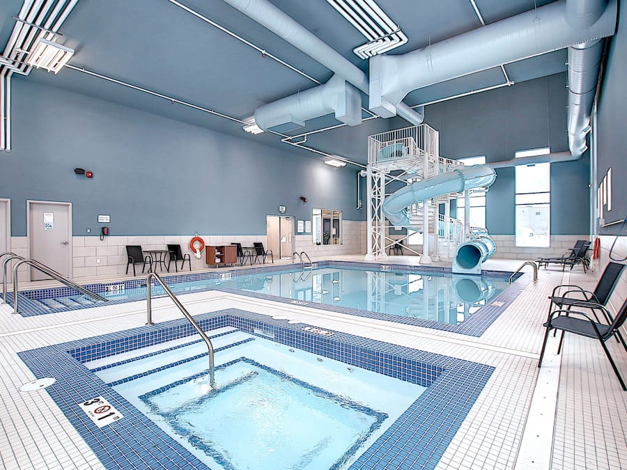 Una piscina techada, sillones reclinables de piscina