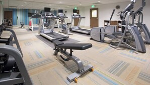 A gym with treadmills, elliptical machines, and weight benches.