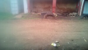 Terreno sterrato con una gomma e detriti sparsi.