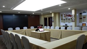 A conference room with a long table, white chairs, and a digital display. - Huangshan Baiyun Hotel (Huangshan)