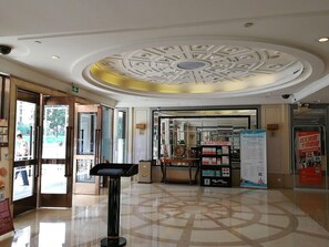 A hotel lobby with a modern ceiling design, a reception desk, and a display board. - Mamaya Apartment Hotel (Shenzhen)