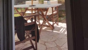 A patio area with outdoor furniture and a large umbrella. - Palm tree house by the beach (Λουτράκι)