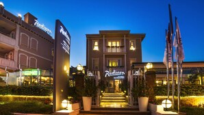 A hotel entrance with steps leading up to a building, a signboard, and flags. - Radisson Hotel Istanbul Sultanahmet (Istanbul)