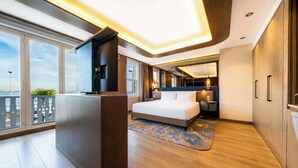 A modern hotel room with a large bed, a TV, a balcony with a view, and wooden flooring. - Radisson Hotel Istanbul Sultanahmet (Istanbul)