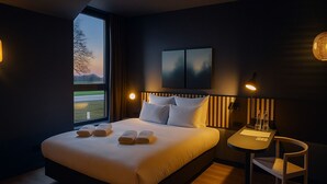 A modern hotel room with a large bed, bedside lamps, a small table, and a view of the outdoors. - Off Meeting Wavre Hotel (Wavre)