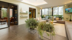 A modern living room with a skylight, large windows, and a cozy seating area. - Off Meeting Wavre Hotel (Wavre)