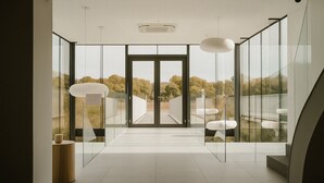 A modern interior with a glass door leading to a balcony, a ceiling-mounted air conditioning unit, and a minimalist design with clean lines. - Off Meeting Wavre Hotel (Wavre)