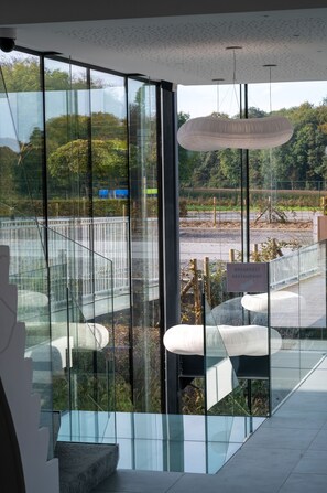 Relax in a stylish space with a large glass wall offering views of the outdoors and a seating area for dining or unwinding.