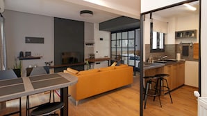 Una cocina moderna con encimera de madera, taburetes de bar y horno empotrado.