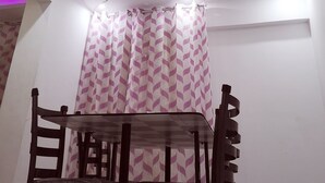 A room with a dining table and chairs, a patterned curtain, and a ceiling with recessed lighting and a square light fixture. - Leila house (new apartment) (Alessandria)