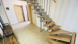 Un escalier en bois avec des rampes en métal menant à une porte.