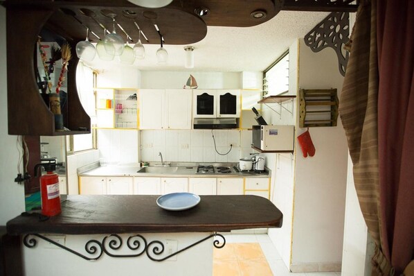 Kitchen features a central island, white cabinetry, stainless steel sink, and gas stove.
