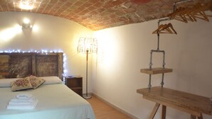 Una camera da letto con un letto, un comodino, una lampada e una mensola in legno.