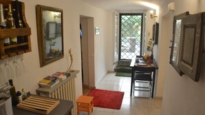 Una cucina con un piano di lavoro in legno, un tappeto rosso e un'area pranzo con tavolo e sedie.