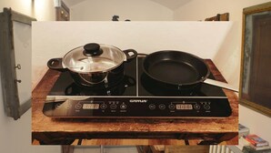 Una cucina con un piano cottura Gaggenau, una pentola sul bruciatore a sinistra e una padella sul bruciatore a destra.
