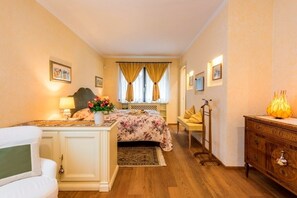 A bedroom with a bed, bedside table, lamp, and a dresser.