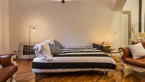 Ein Schlafzimmer mit Bett, Schreibtisch, Stuhl und Stehlampe.