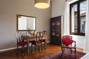 A dining area with a wooden table, chairs, a mirror, and a cabinet.