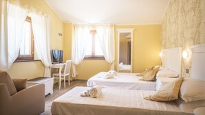 A hotel room with two beds, a desk, a chair, and a TV. - La Dimora di Francesco (Assisi)