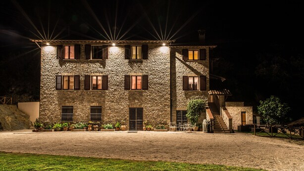 A stone building with multiple windows and a staircase leading to an upper level. - La Dimora di Francesco (Assisi)