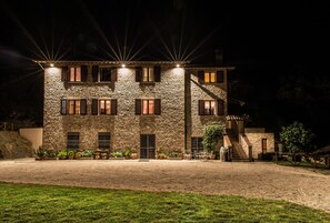 A stone building with multiple windows and a staircase leading to an upper level. - La Dimora di Francesco (Assisi)