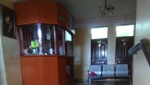 Un vestíbulo amplio con una mesa de recepción, un banco y una escalera.