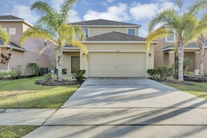 Una casa residenziale con un portone garage beige, il numero 2616 e un vialetto che conduce al garage.