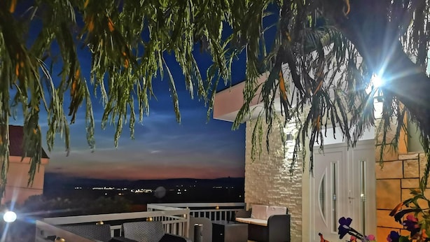 Un espacio de asientos al aire libre con vista a la ciudad al anochecer.