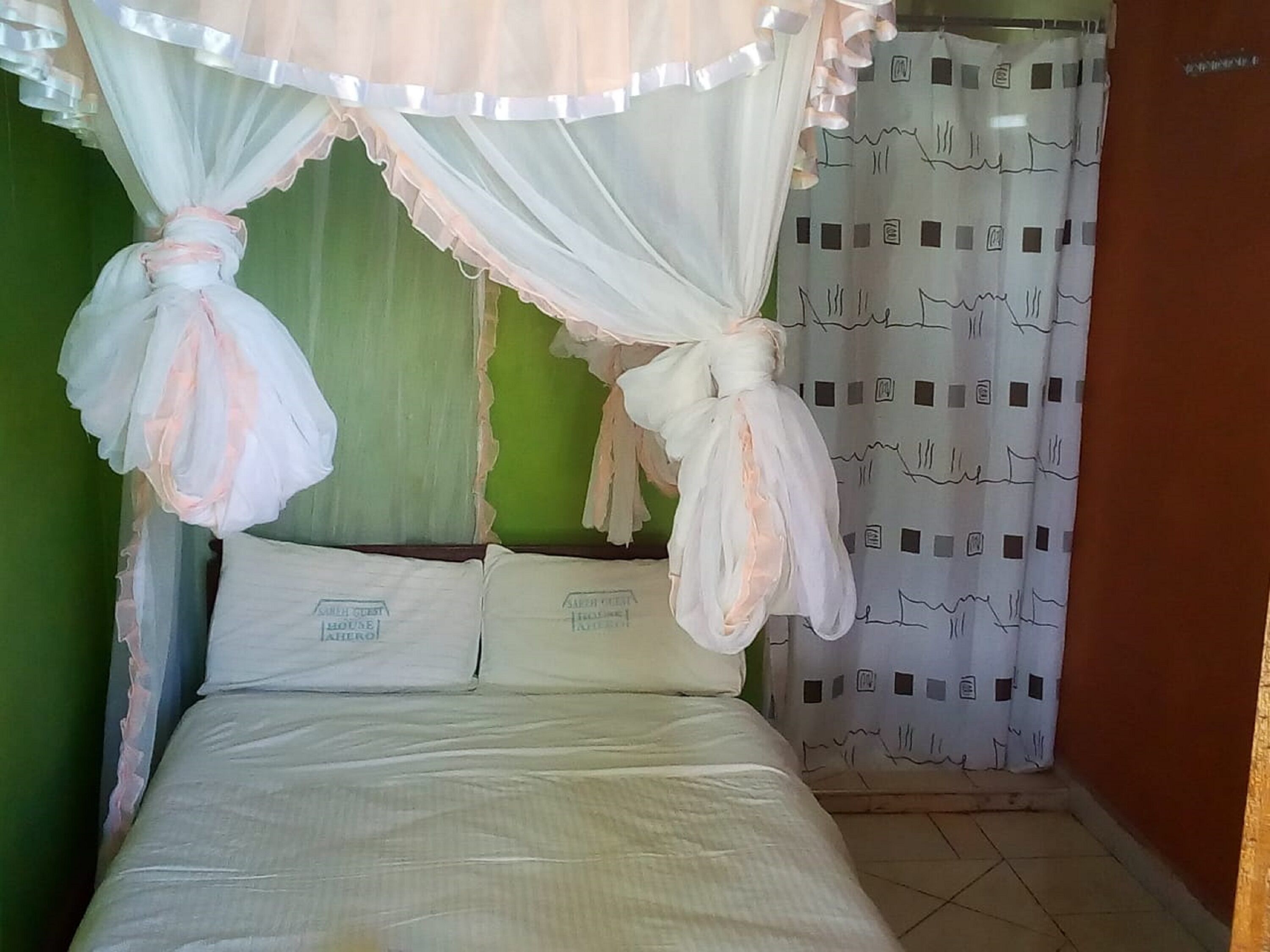 Un dormitorio con cama, ropa de cama blanca y dosel.
