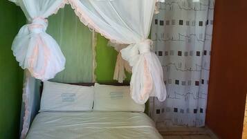 Un dormitorio con cama, ropa de cama blanca y dosel.