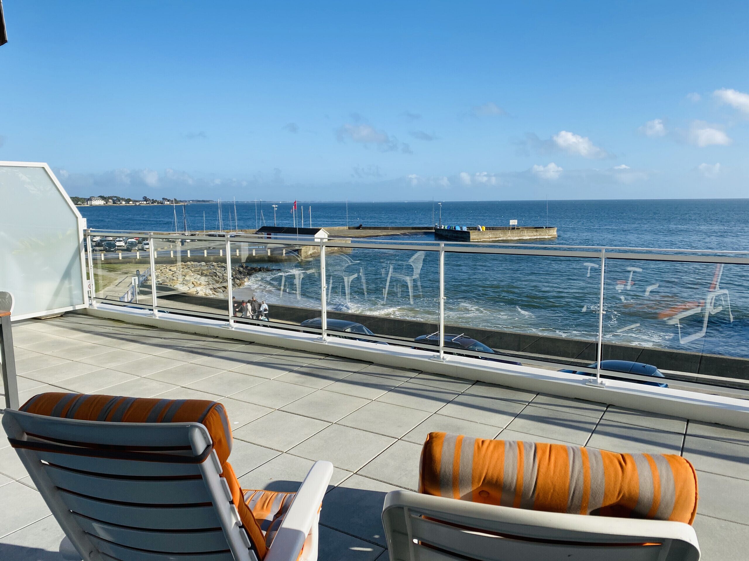 Una terraza con dos sillas y vista al mar.
