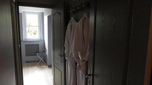 A hallway with a door leading to a room, a drying rack, and a window with natural light. - Le Clos Saint Sulpice (Fossé)